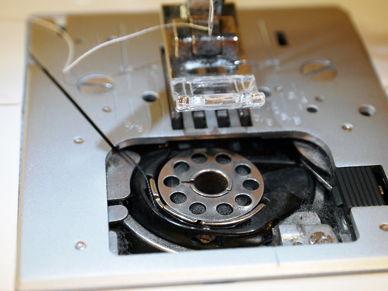 Metal bobbin in the hook with the needle plate taken off