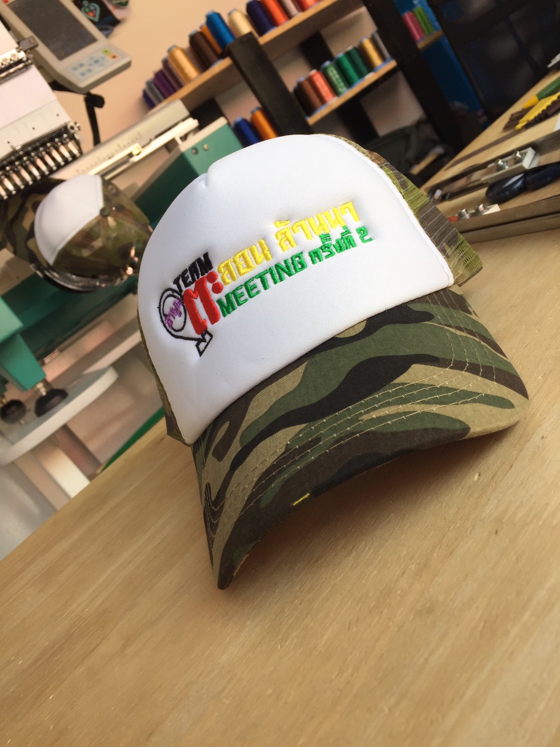 Camouflage trucker cap with an embroidered logo on the front panel