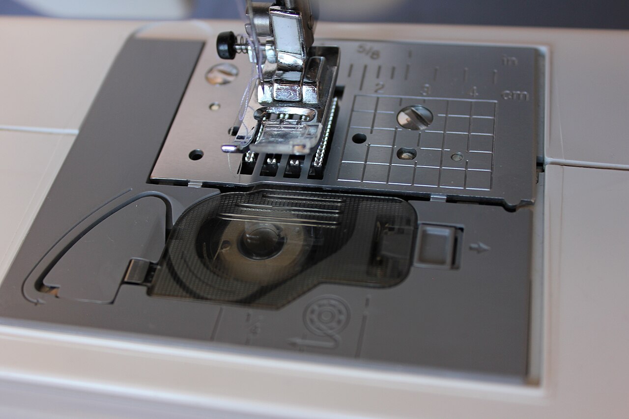 Drop-in bobbin seen under a clear cover below the needle plate