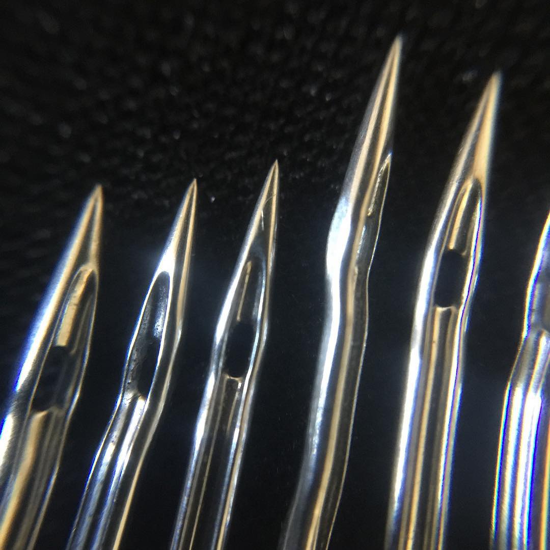 Macro view of several machine needle points and eyes