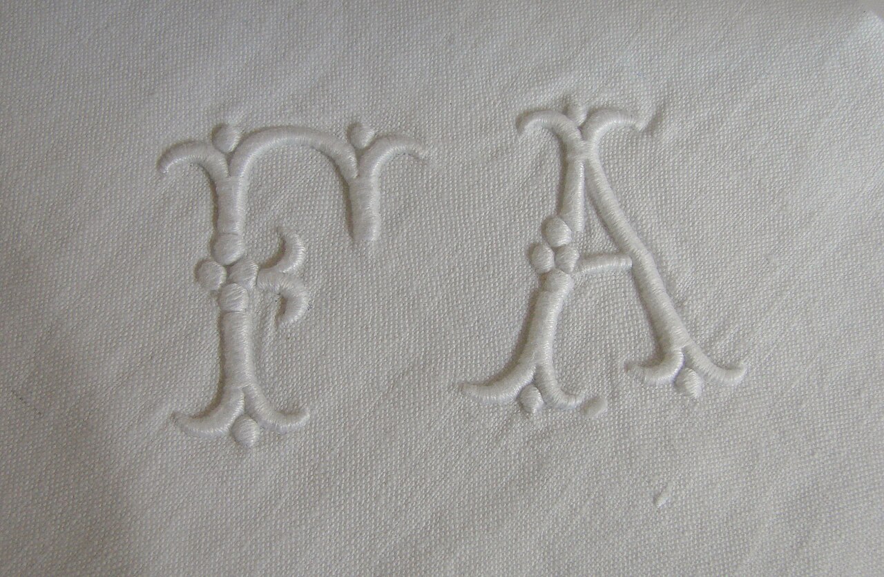 White satin-stitched monogram letters F and A on linen