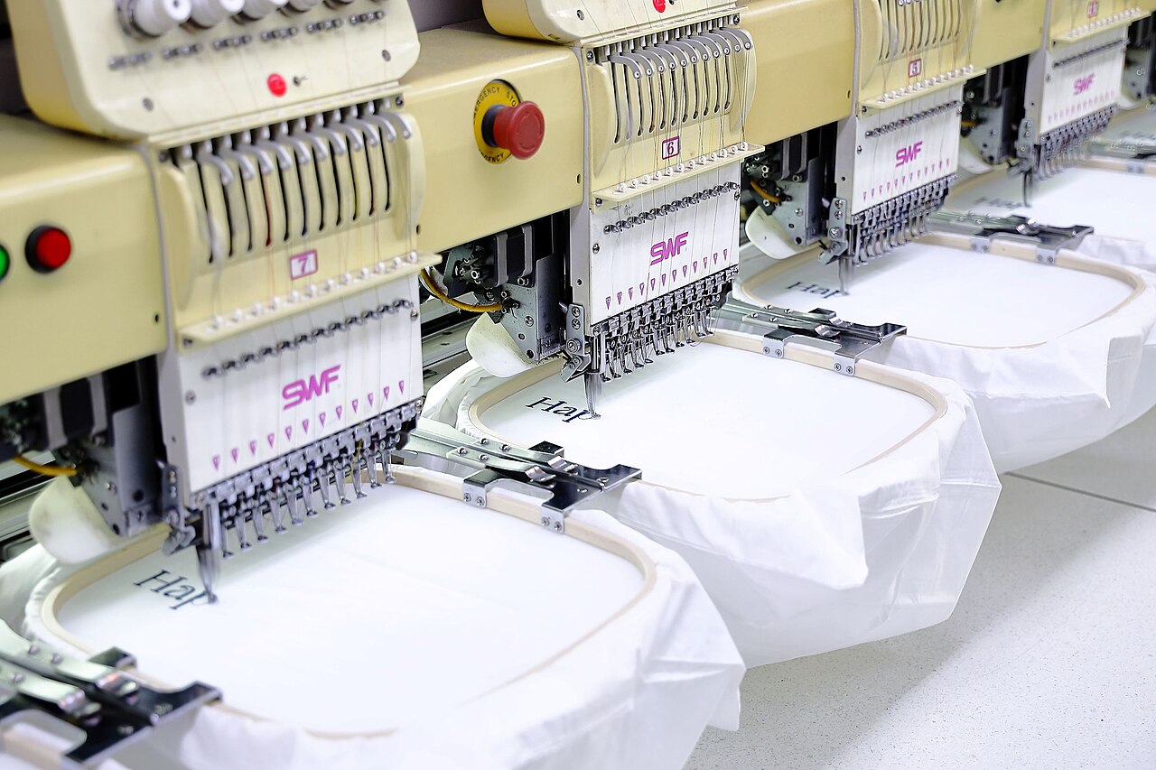 Row of SWF embroidery heads with hooped white garments