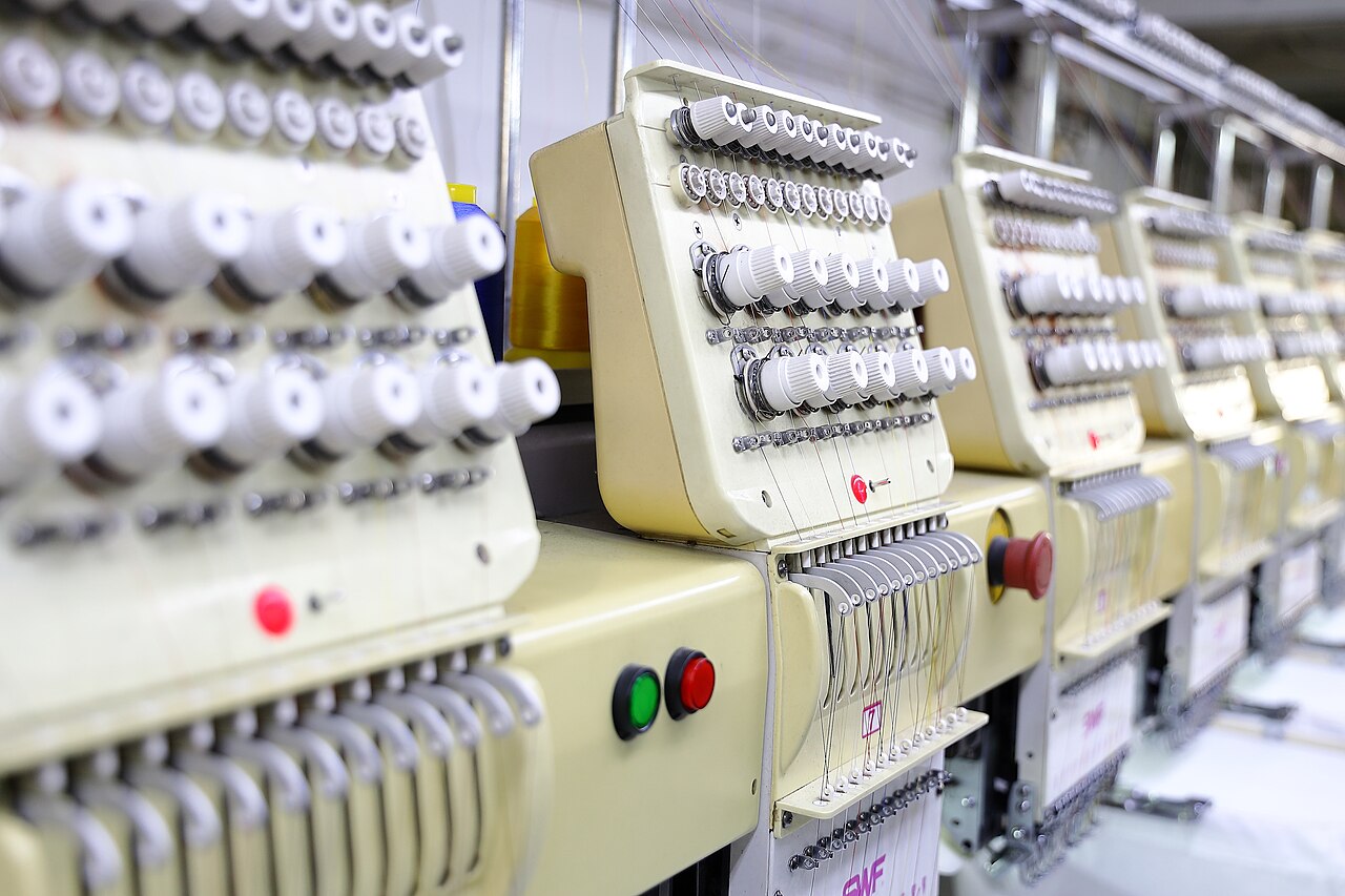 Rows of white tension knobs on SWF multi-head embroidery machines